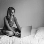 Memorise a speech overnight. A women sits at a laptop in bed.