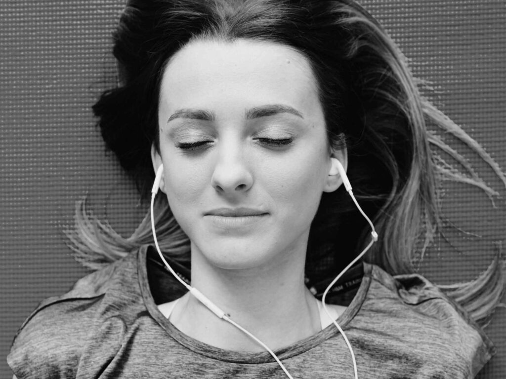 A young woman listening to headphones.