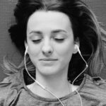 A young woman listening to headphones.