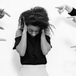 A nervous speaker being pointed at by others.